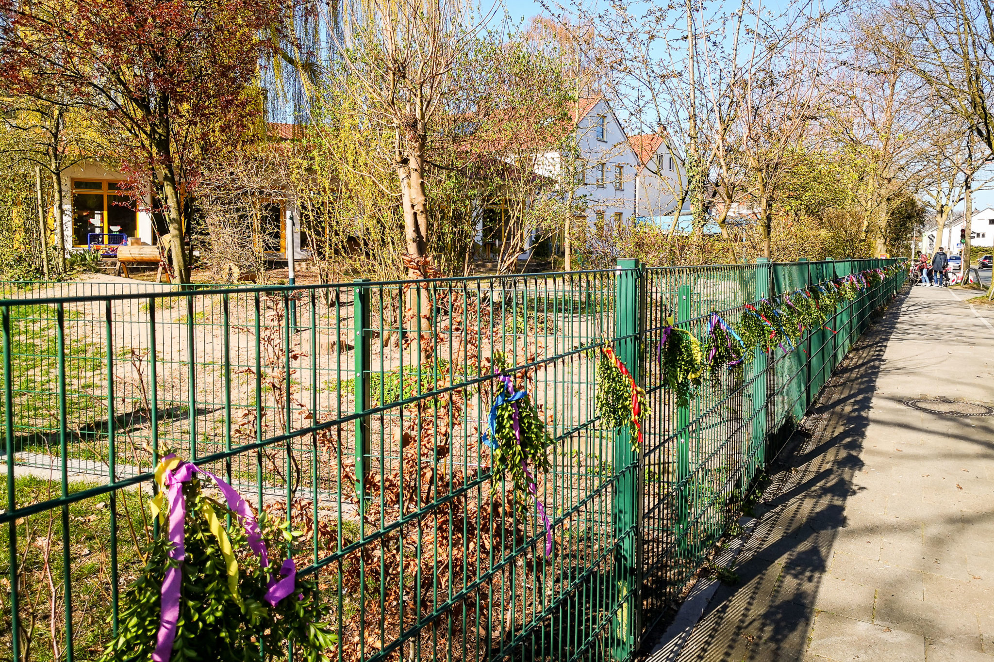 Wir haben uns überlegt, den Zaun trotzdem mit Buchsbaumzweigen zu schmücken um an den Einzug in Jerusalem zu erinnern. Sie alle sind eingeladen, in der Karwoche, auf einem Ihrer Spaziergänge, einen geschmückten Buchsbaumzweig vom Zaun zunehmen. Nehmen Sie ihn als Symbol der Vorbereitung auf Ostern und als kleinen Gruß der Mitarbeiterinnen an Sie und Ihre Kinder.